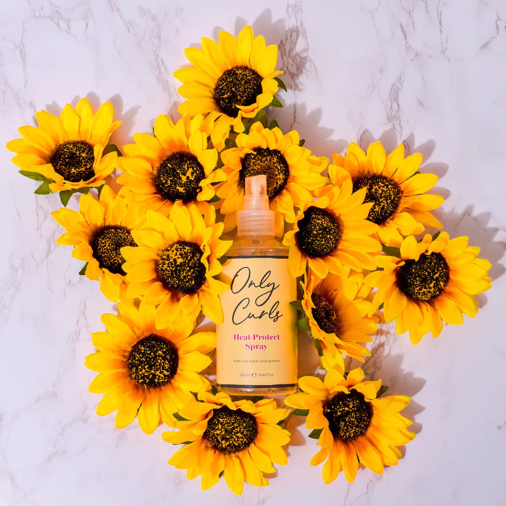 Only Curls Heat Protect Spray omringd door zonnebloemen als sfeerfoto